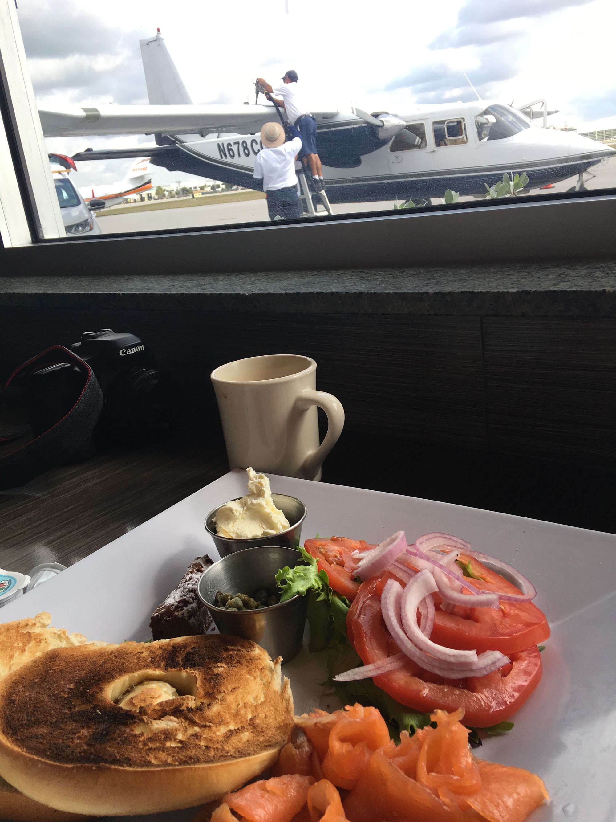 An image of a plate of food while an airplane fuels in the background.